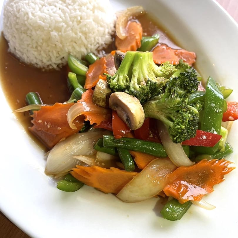 Origin Thai Bistro's stir-fried mixed vegetables with white rice on a white plate.